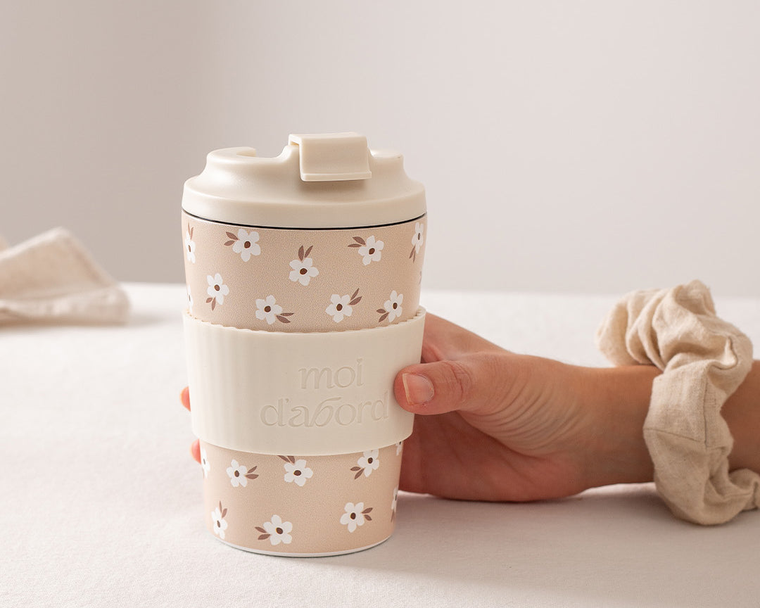 Tasse de voyage isotherme Champ crème de Moi d’abord, beige avec petites fleurs crème et manchon assorti